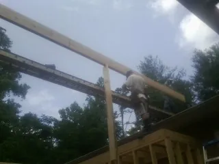 Carpenter setting a ridge beam over a new addition frame — Ice Dam Removal by Roofing Brothers in Stone Ridge