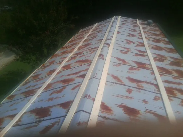 Rusted metal roof panels with new wood purlins before replacement — Storm Damage Roof Repair in Stone Ridge by Roofing Brothers