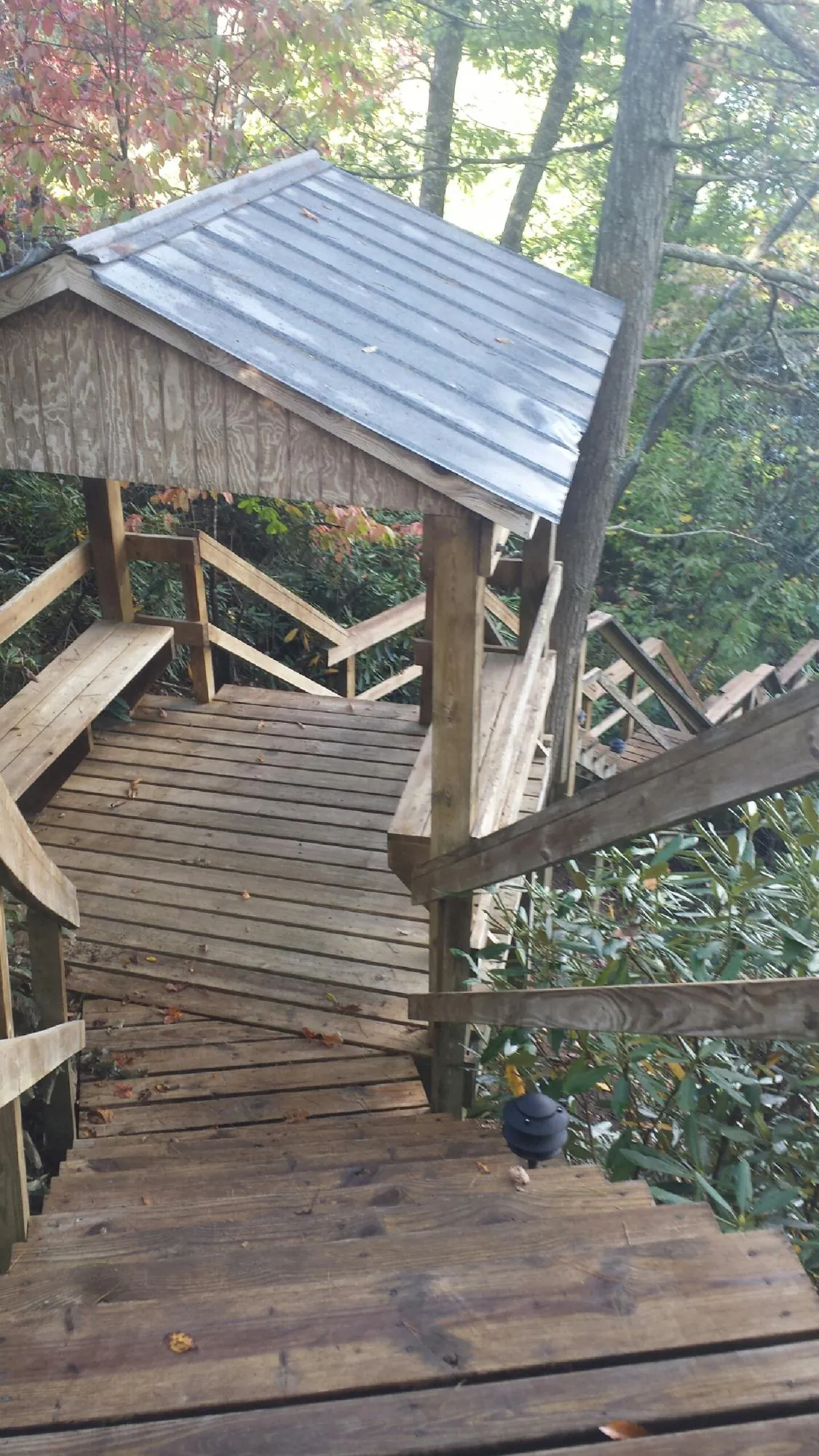 Metal roofed shelter over wooden steps on a wooded walkway — Skylight Repair & Installation work by our crew in Stone Ridge