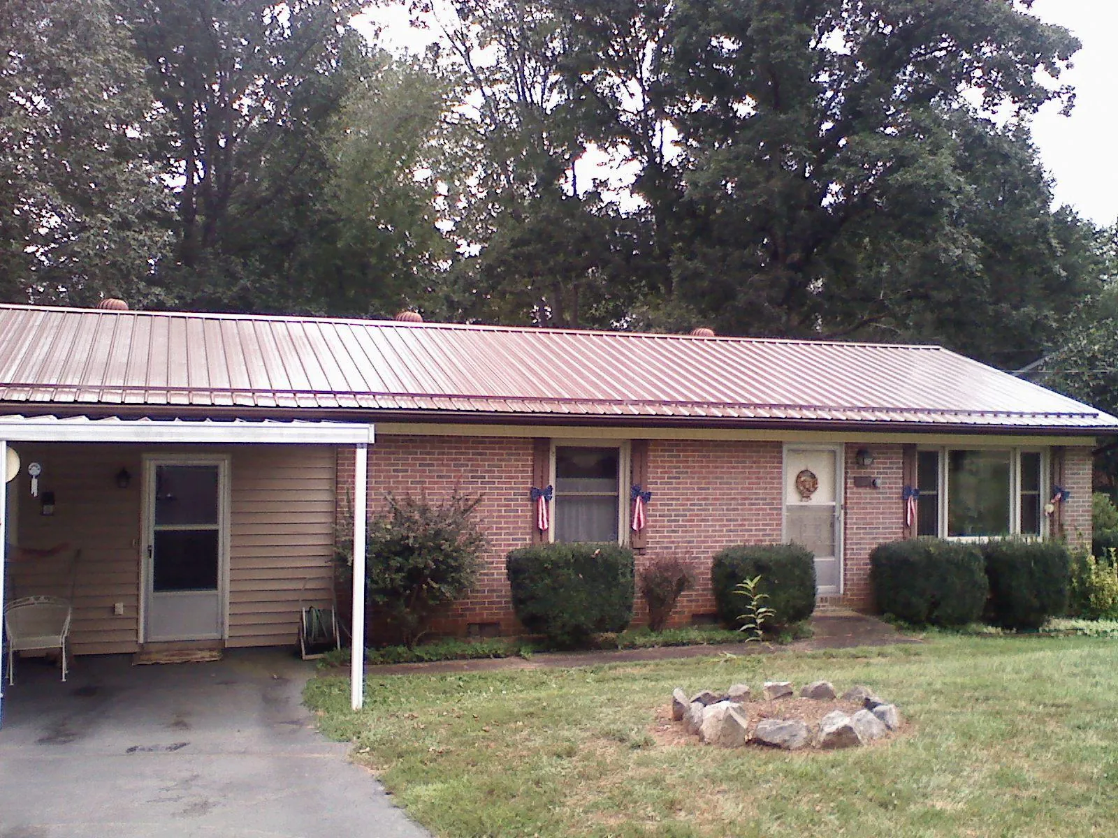 Bronze metal roof and carport on a brick ranch home — Roof Repair work by our crew in Stone Ridge